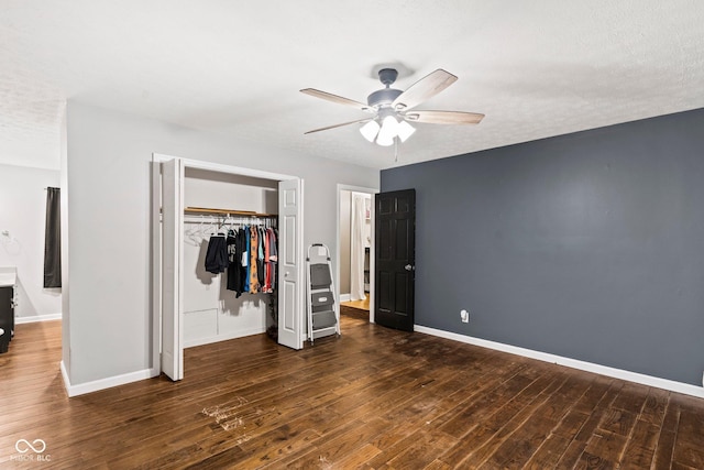 unfurnished bedroom featuring a closet, baseboards, wood finished floors, and a ceiling fan