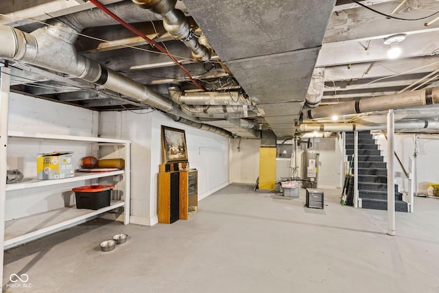 unfinished basement featuring water heater, stairway, and heating unit