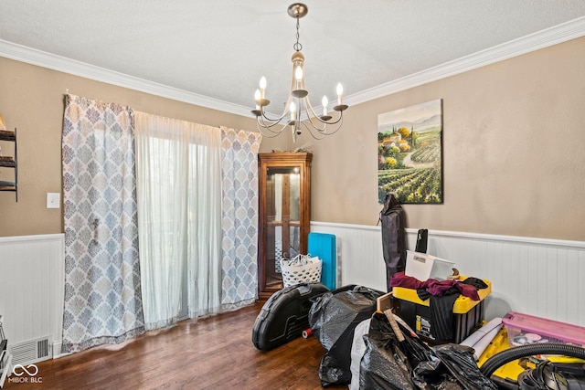 dining space with crown molding, a wainscoted wall, radiator heating unit, an inviting chandelier, and wood finished floors