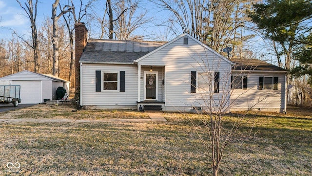 view of front of property featuring a shingled roof, a detached garage, a front yard, a chimney, and an outbuilding