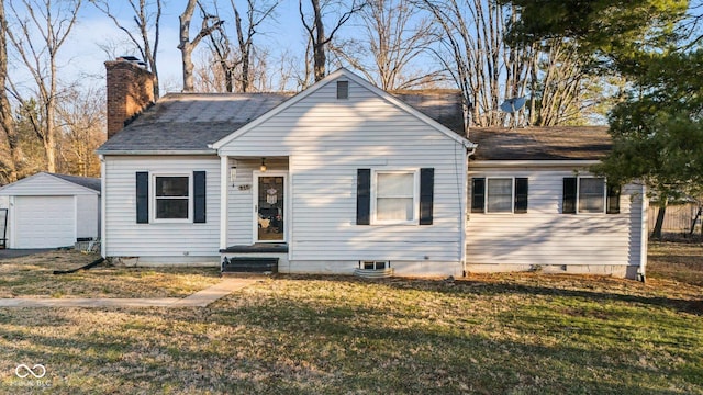 bungalow featuring a front yard, roof with shingles, a chimney, a garage, and an outbuilding