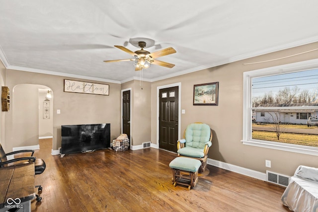 sitting room featuring visible vents, arched walkways, baseboards, and wood finished floors