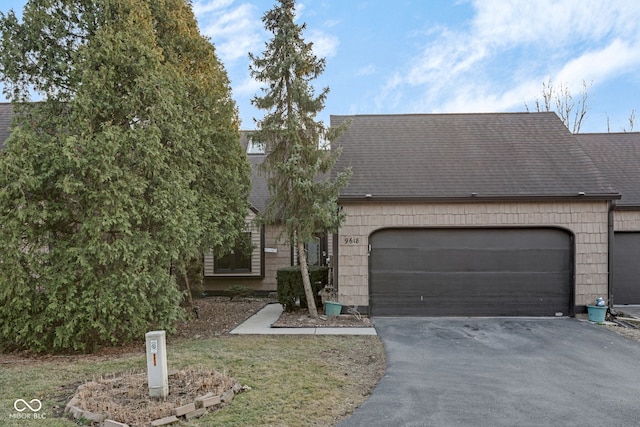 view of front of home featuring aphalt driveway, an attached garage, and a shingled roof