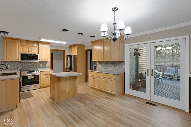 kitchen featuring light brown cabinets, a kitchen island, light countertops, french doors, and appliances with stainless steel finishes