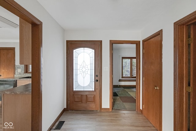 foyer featuring light wood finished floors, visible vents, and baseboards