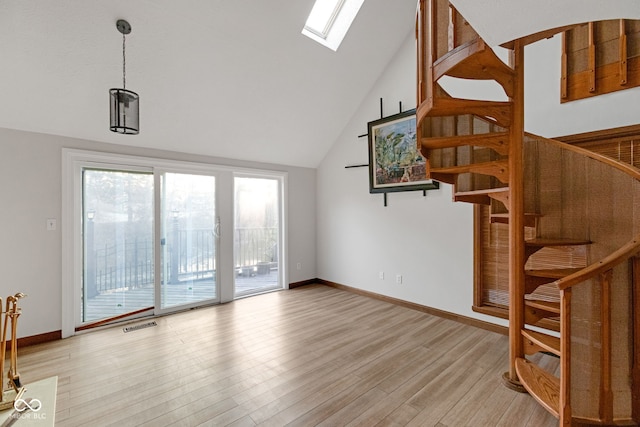 living room with visible vents, baseboards, stairway, vaulted ceiling with skylight, and light wood-style flooring