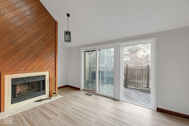 unfurnished living room with a premium fireplace, visible vents, baseboards, and wood finished floors