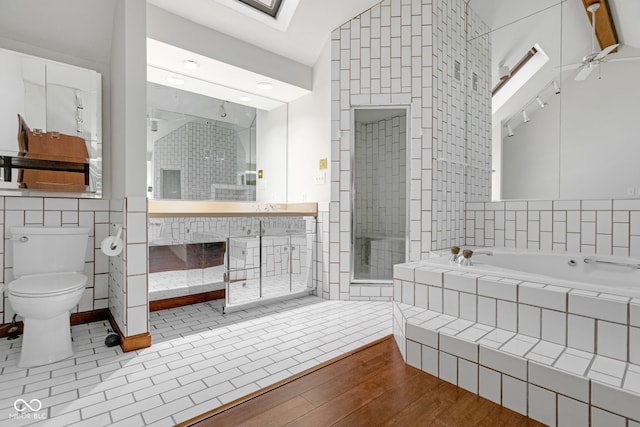 full bathroom with vanity, wood finished floors, a shower stall, a garden tub, and toilet