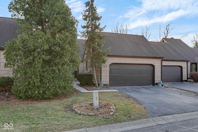 view of front of home featuring a garage, roof with shingles, and driveway