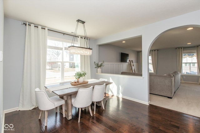 dining space with recessed lighting, baseboards, arched walkways, and wood finished floors