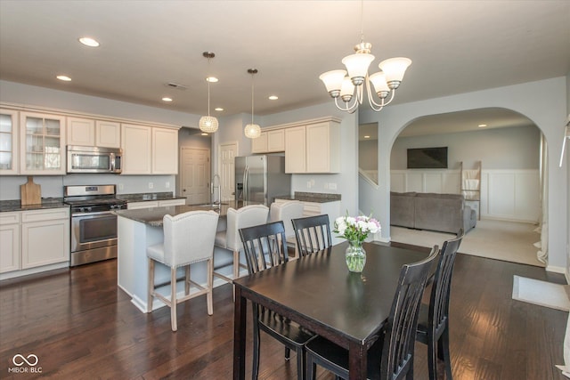 dining room featuring visible vents, dark wood finished floors, a chandelier, recessed lighting, and arched walkways