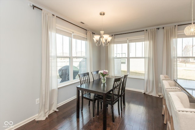 dining space featuring plenty of natural light, dark wood-style floors, visible vents, and a chandelier