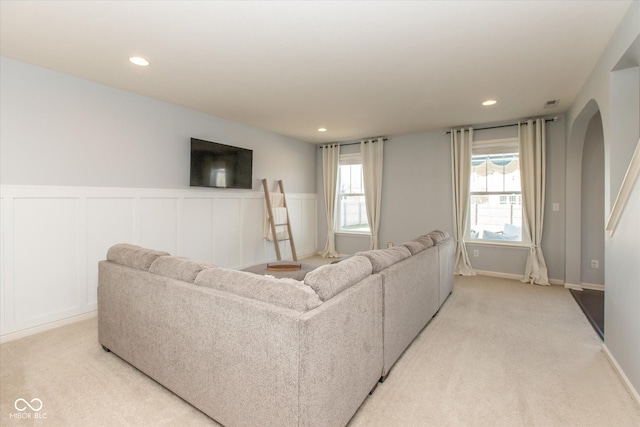 living room with recessed lighting, arched walkways, and light carpet