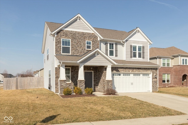 view of front of house with a front lawn, a garage, fence, and stone siding