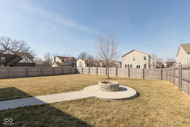 view of yard featuring a fire pit, a residential view, and a fenced backyard