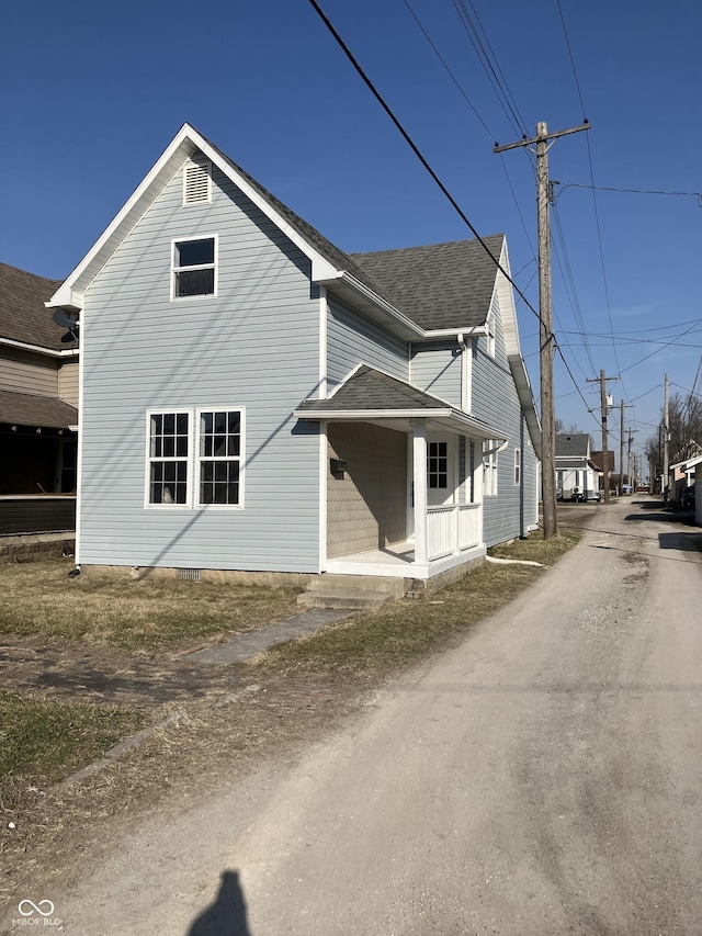 exterior space featuring a porch and roof with shingles