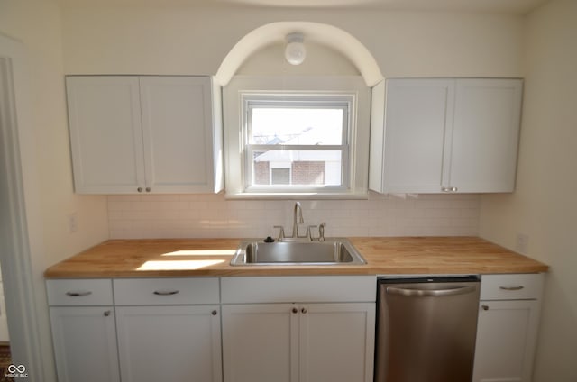 kitchen with dishwasher, decorative backsplash, a sink, and butcher block counters