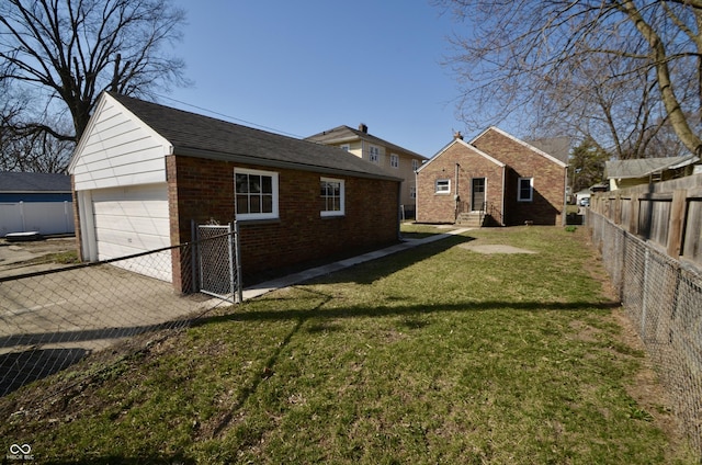 rear view of property featuring brick siding, a lawn, an outbuilding, and fence