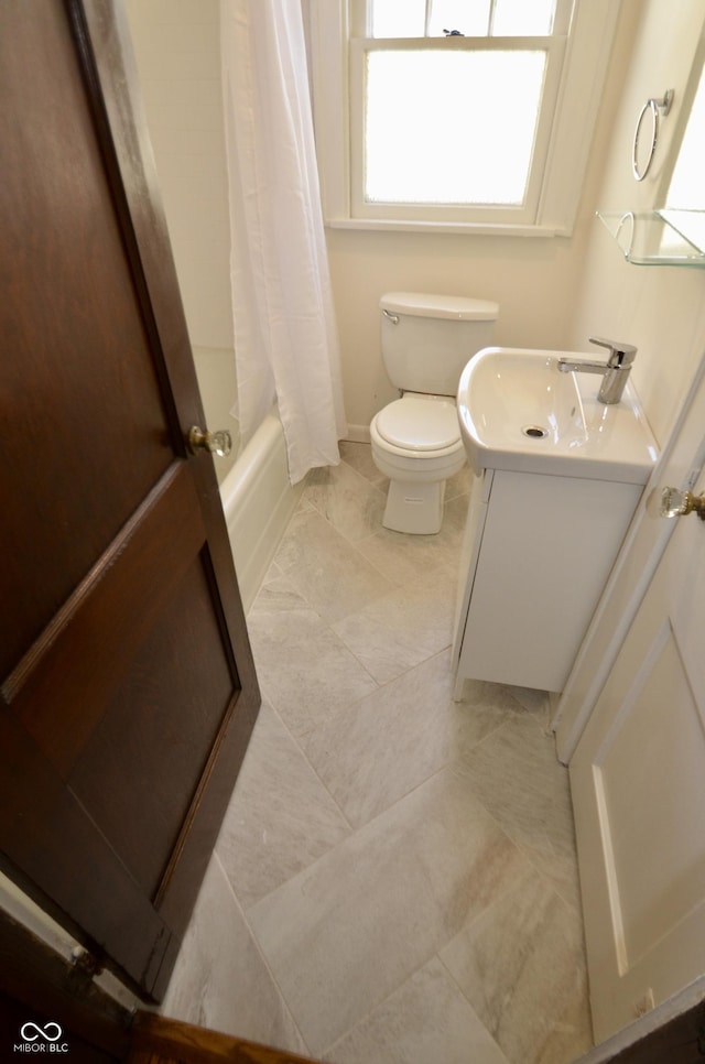 bathroom featuring toilet, vanity, and shower / tub combo