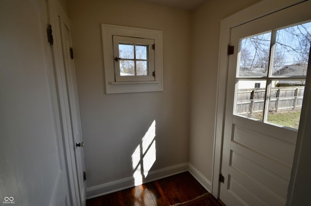 doorway featuring baseboards and dark wood-style floors