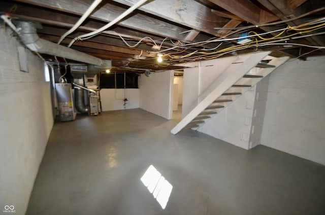 unfinished below grade area with water heater, heating unit, and stairs