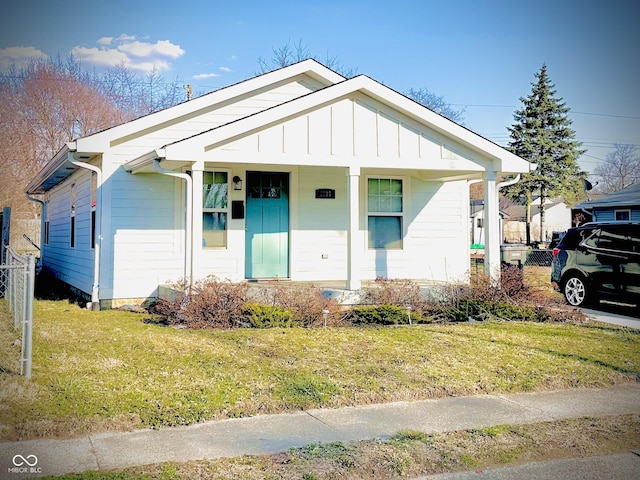 bungalow-style home with a front lawn and board and batten siding