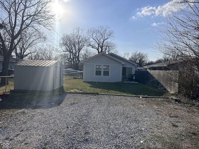 exterior space featuring a yard, fence, an outdoor structure, and a shed