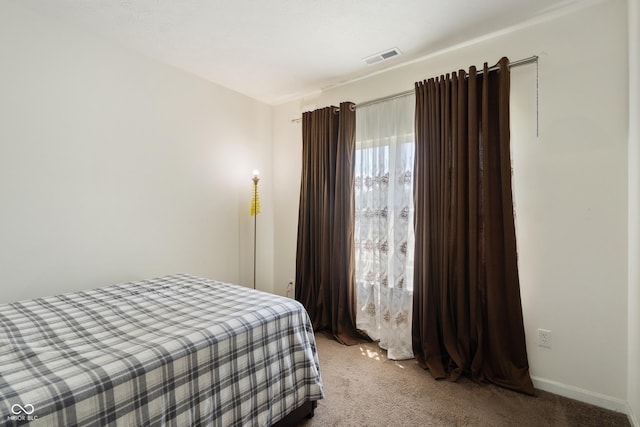 bedroom featuring visible vents, light carpet, and baseboards