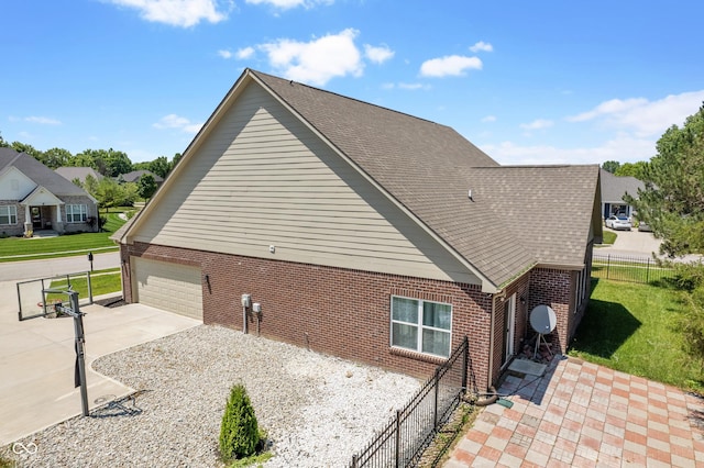 view of side of property featuring concrete driveway, fence, brick siding, and a lawn