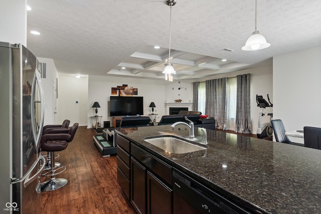 kitchen with coffered ceiling, freestanding refrigerator, a sink, dark wood-type flooring, and a textured ceiling