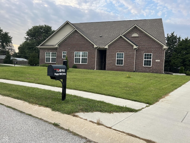 view of front of home with a front lawn and brick siding