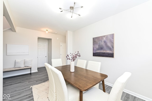 dining area with a notable chandelier, baseboards, and wood finished floors