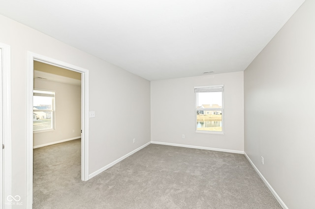 unfurnished room featuring baseboards and carpet