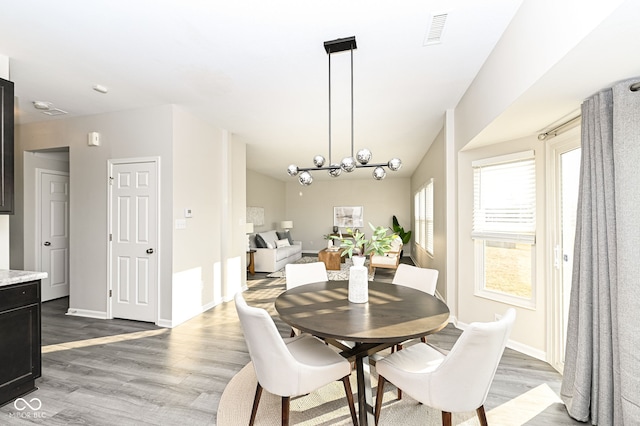 dining space featuring visible vents, baseboards, and wood finished floors