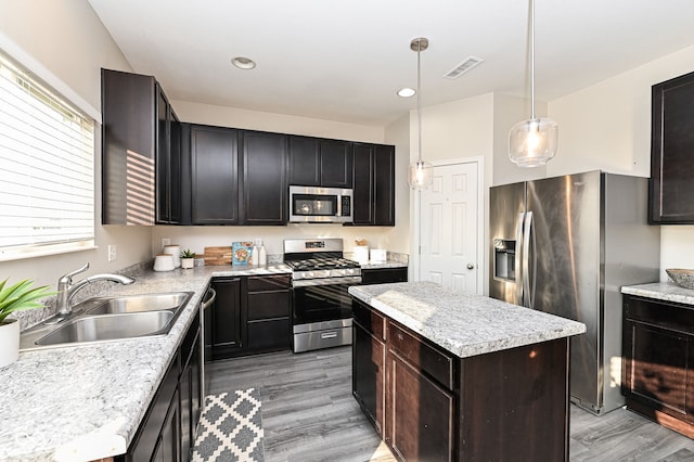 kitchen featuring visible vents, a sink, stainless steel appliances, light countertops, and light wood-type flooring