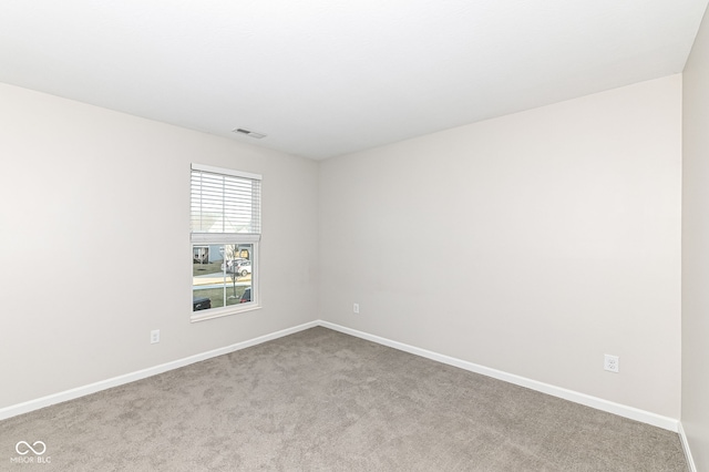 unfurnished room with visible vents, baseboards, and carpet floors