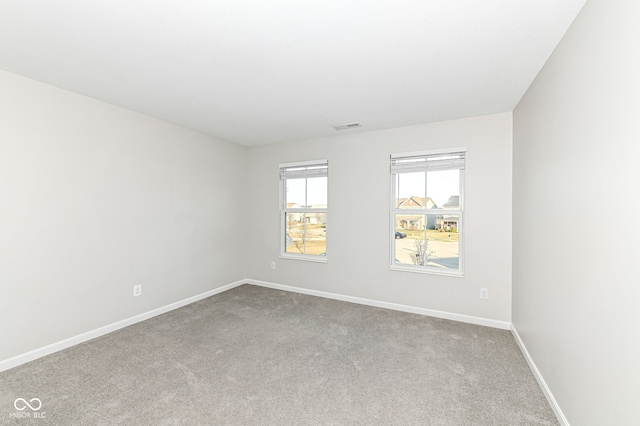 spare room with visible vents, baseboards, and carpet floors