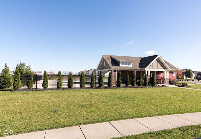 view of front of home featuring board and batten siding, a front lawn, and fence