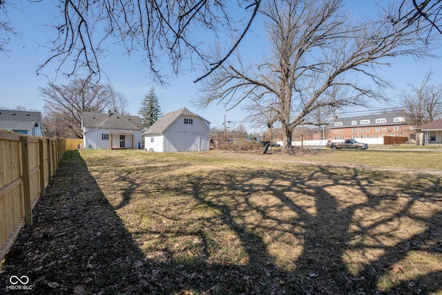 view of yard featuring a residential view, an outbuilding, and fence