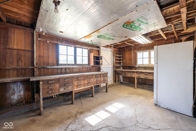 miscellaneous room with wooden walls and concrete floors