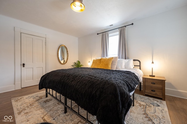 bedroom with light wood-style floors, visible vents, and baseboards