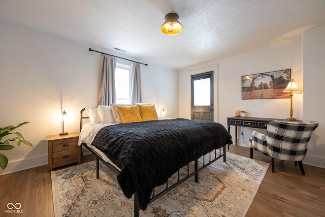 bedroom with visible vents, multiple windows, baseboards, and light wood-style flooring