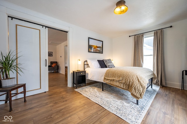 bedroom featuring wood finished floors and baseboards