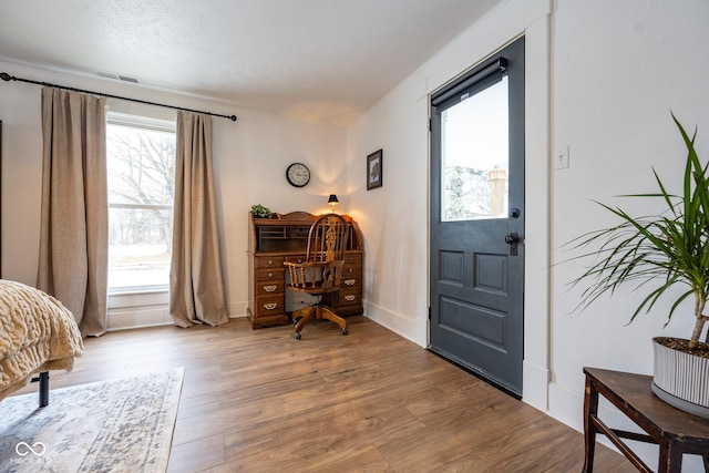 entryway featuring visible vents, baseboards, and wood finished floors