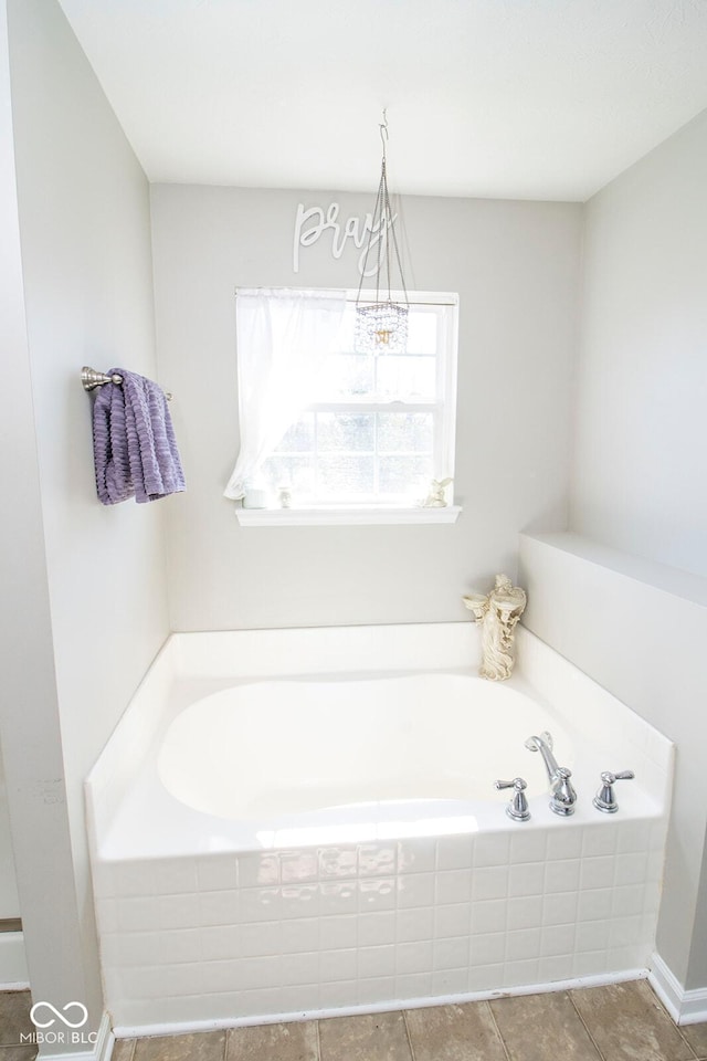 bathroom with tile patterned floors and a garden tub