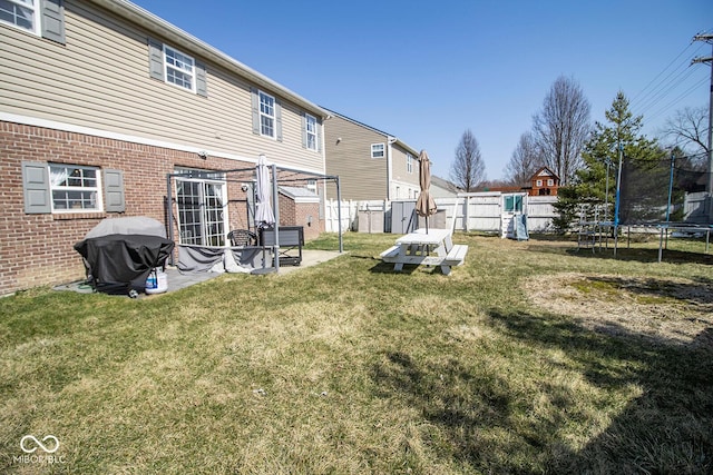 view of yard with a fenced backyard, a patio area, and a trampoline