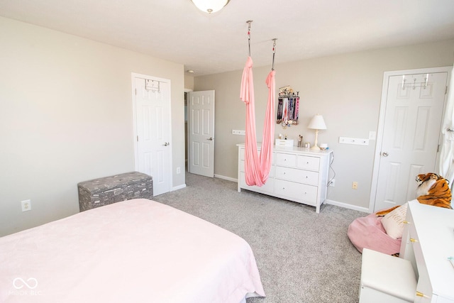 bedroom with baseboards and light carpet