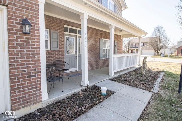 entrance to property featuring brick siding and a porch