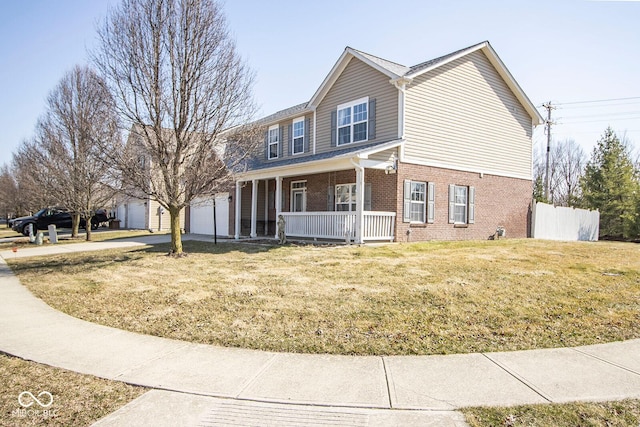 traditional-style house featuring a front yard, fence, a porch, a garage, and brick siding