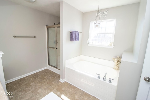 full bathroom with baseboards, a stall shower, and a bath